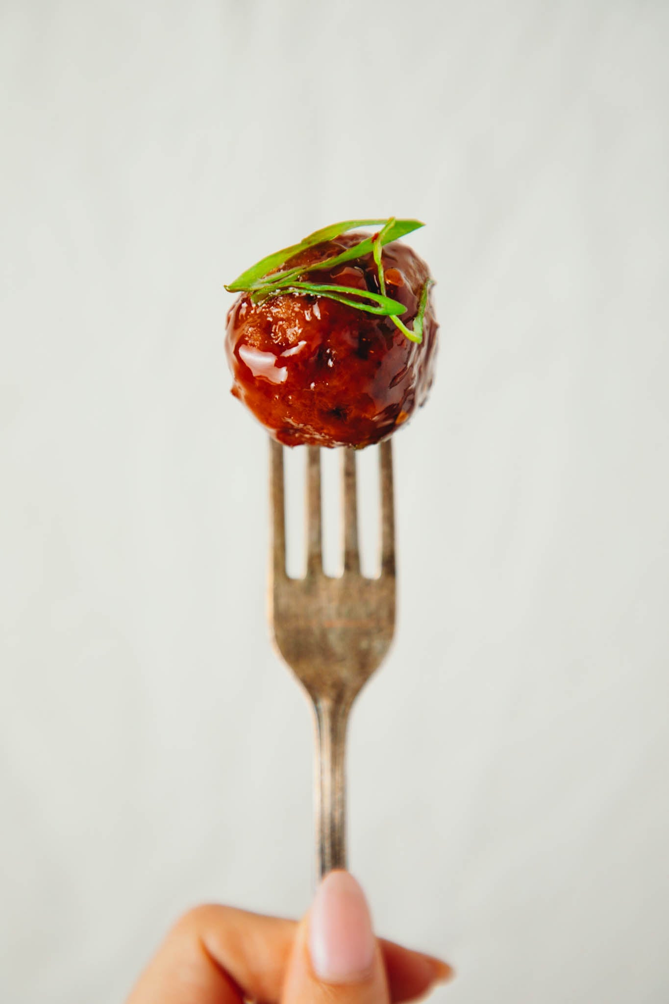 fork holding up a vegan honey garlic meatball