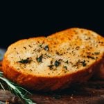 food photography overhead of thick cut vegan garlic bread with golden brown edges and rosemary seasoning