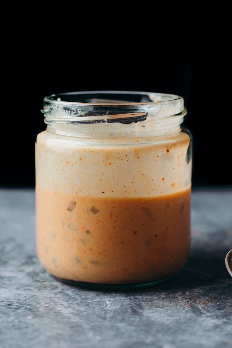 front view of vegan creamy Big Mac sauce in a class jar displaying chunks of fresh pickle