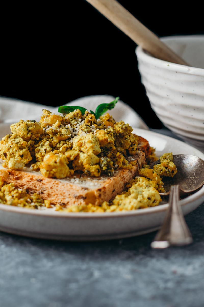 food photography of high protein vegan tofu scramble on toast with a black background.