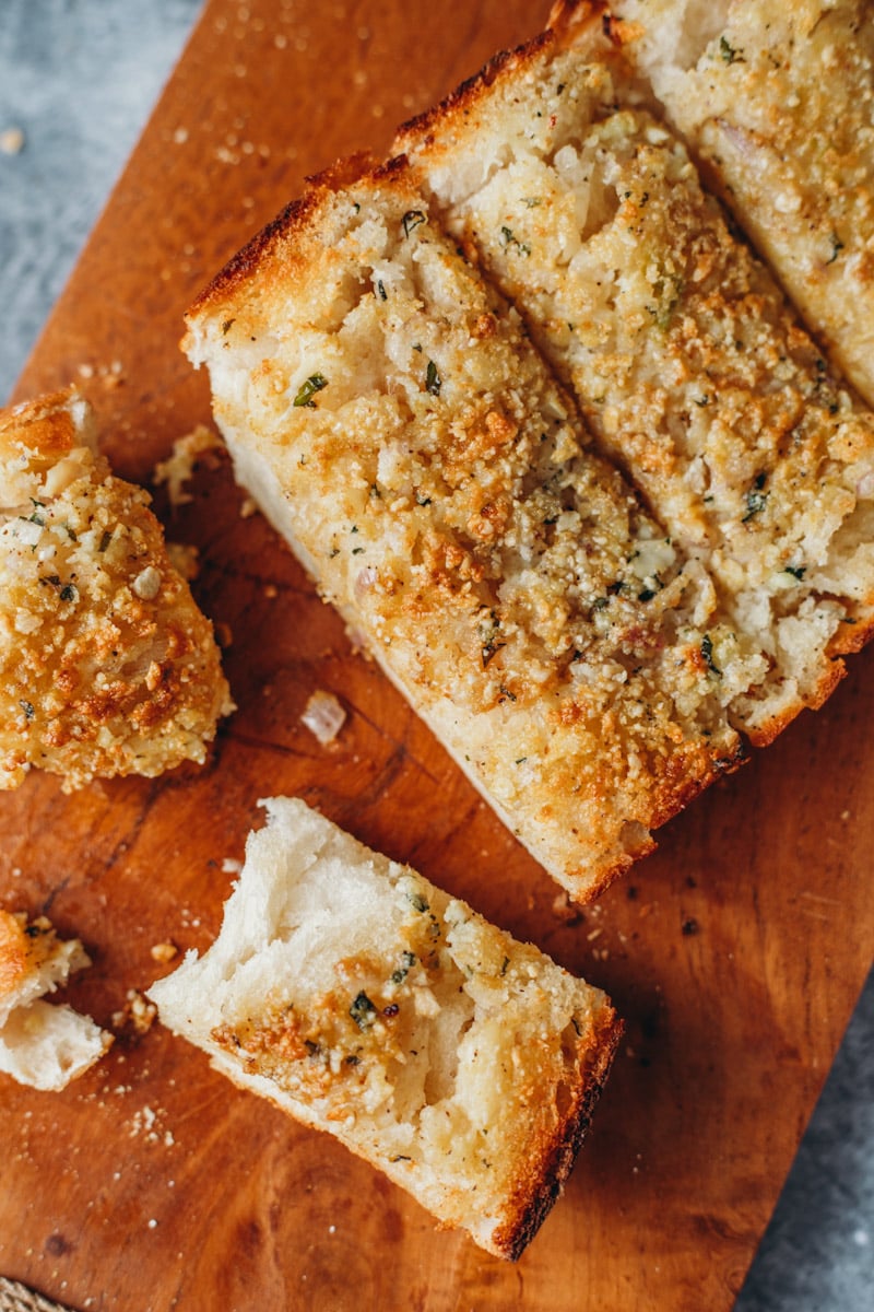 food photography of the best vegan garlic bread using fresh baked garlic, Italian loaf and vegan parmesan