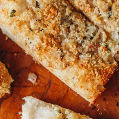 food photography of the best vegan garlic bread using fresh baked garlic, Italian loaf and vegan parmesan