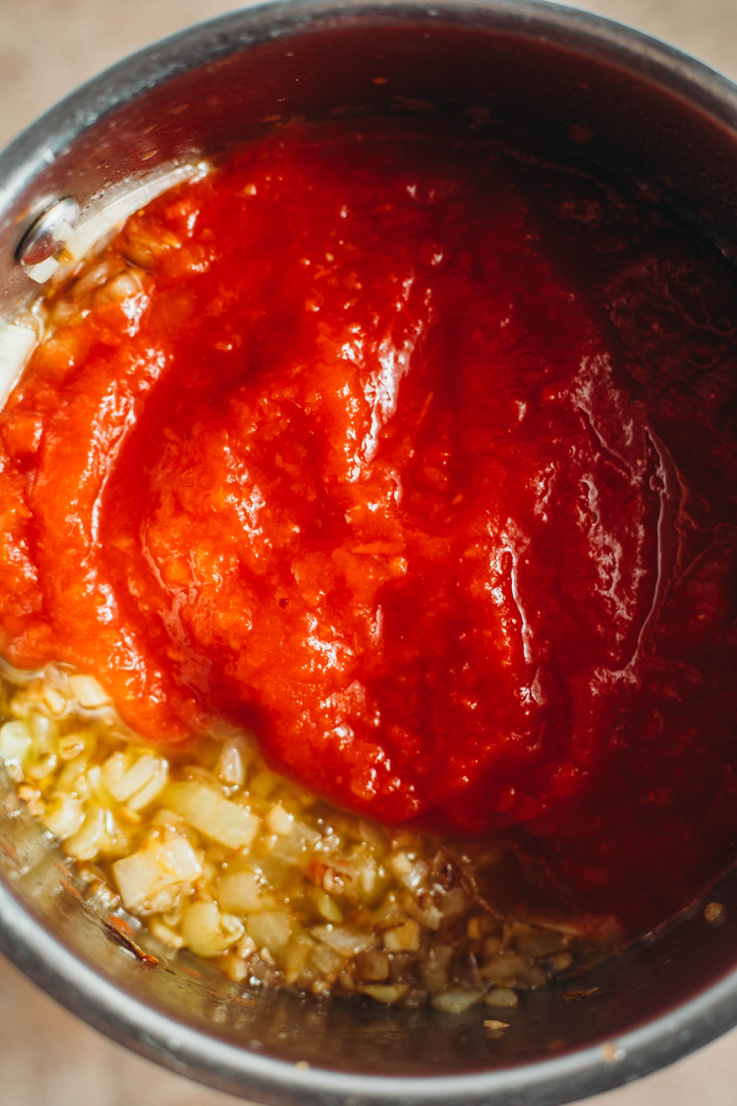 overhead view of tomatoes poured into pot.